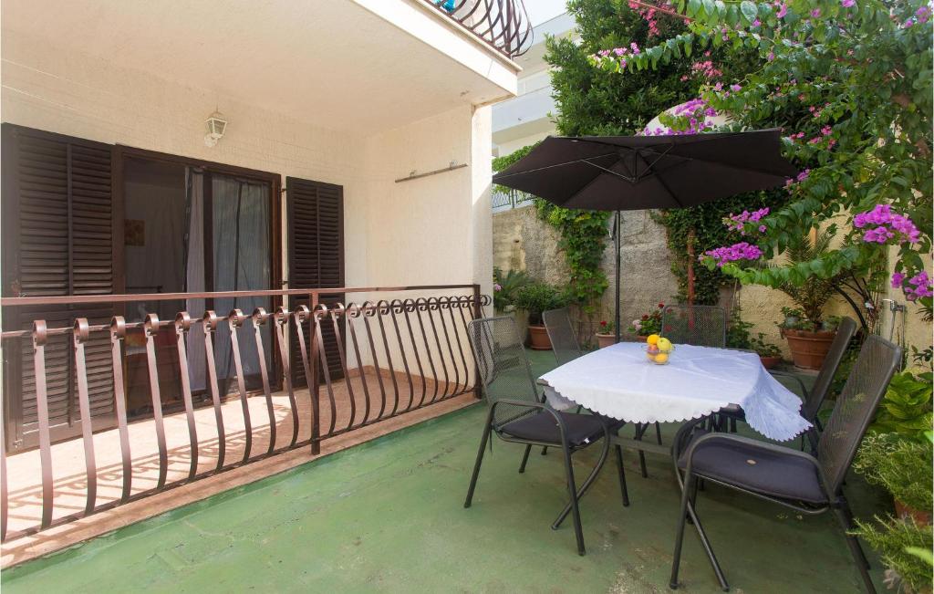 einen Tisch und Stühle mit Sonnenschirm auf dem Balkon in der Unterkunft Cozy Apartment In Podstrana With Wifi in Podstrana