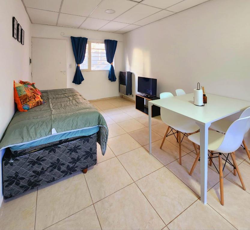 a bedroom with a bed and a table with chairs at Departamento Viajeros Ruta 6 in General Roca