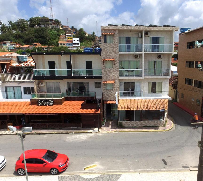 un coche rojo estacionado frente a un edificio en Pousada Tartaruga, en Maragogi