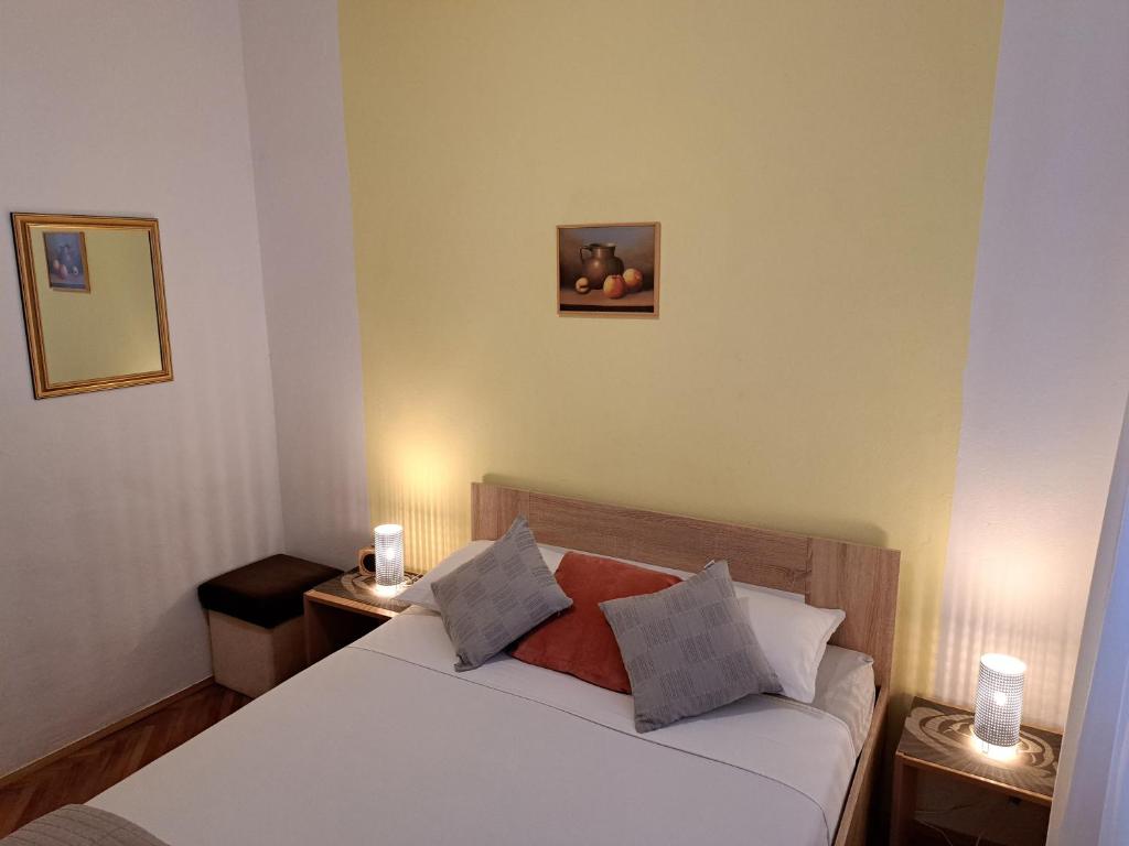 ein Schlafzimmer mit einem weißen Bett und zwei Nachttischen in der Unterkunft Maria's Place in Korčula