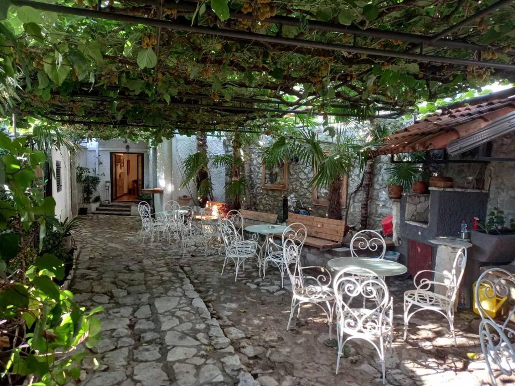 a patio with tables and chairs under a pergola at HeArt of Old Town Guesthouse in Podgorica