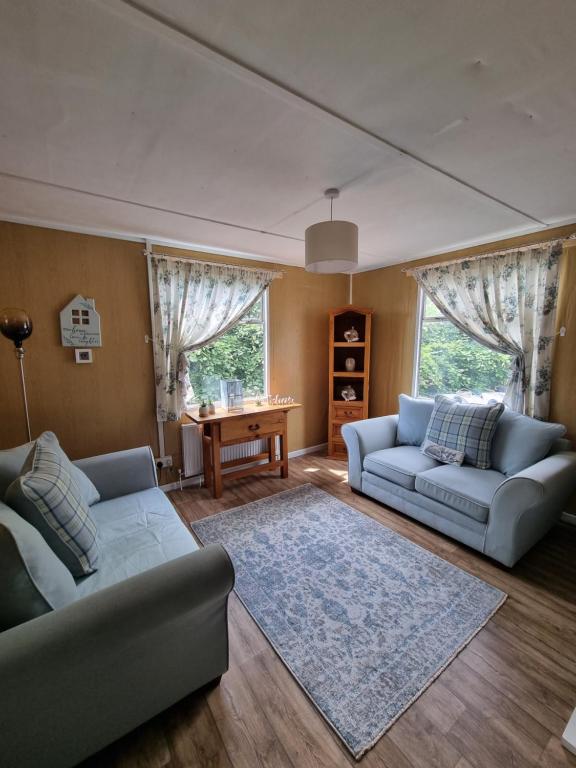 Sala de estar con 2 sofás y mesa en Firbog Nook en Antrim