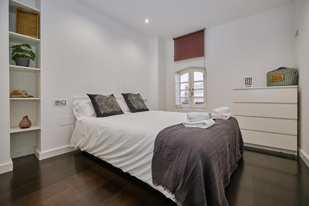 1 dormitorio con 1 cama con sábanas y almohadas blancas en Galera51 by Serendipia Turismo en A Coruña