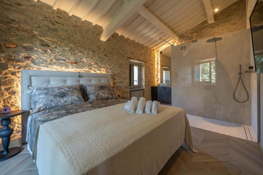 a bedroom with a bed and a stone wall at Forma Your Boutique Suite in Corciano