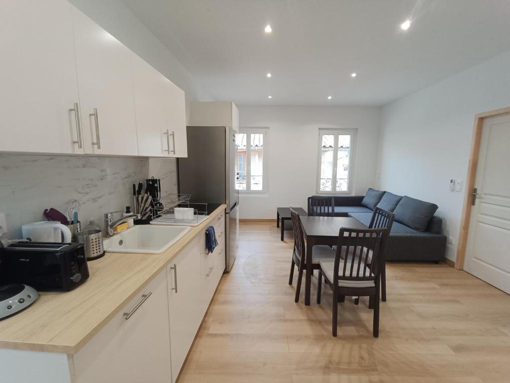 une cuisine et un salon avec une table et un canapé dans l'établissement T3 rénové en 2023, Intra muros Avignon, à Avignon