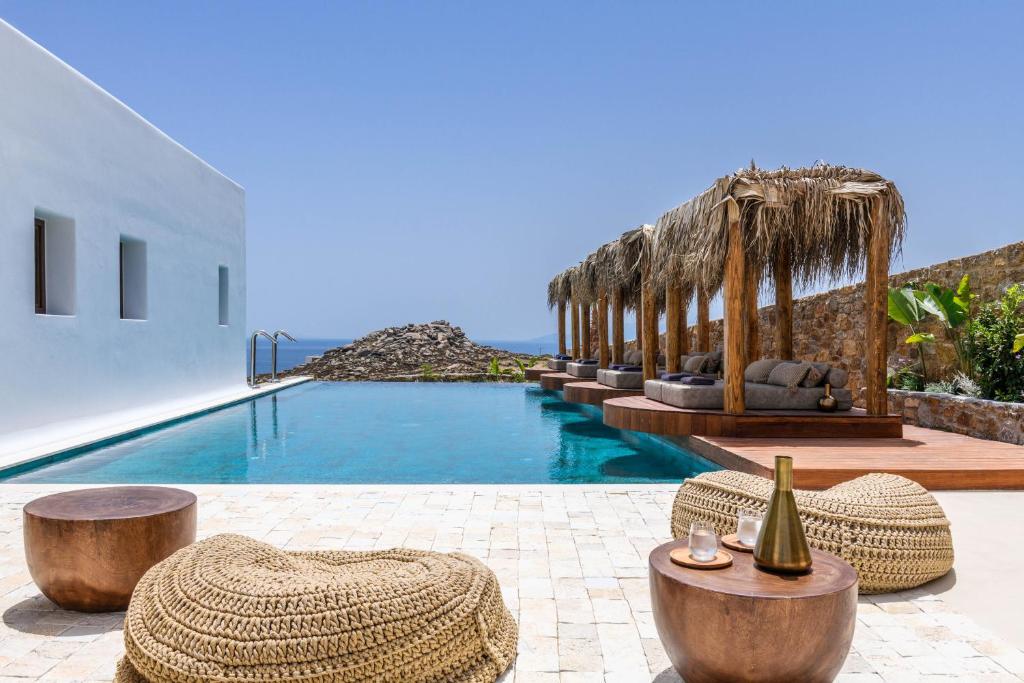 - une piscine avec des chaises et une bouteille de vin dans l'établissement Charisma Hotel and Wellness Suites, à Plintri