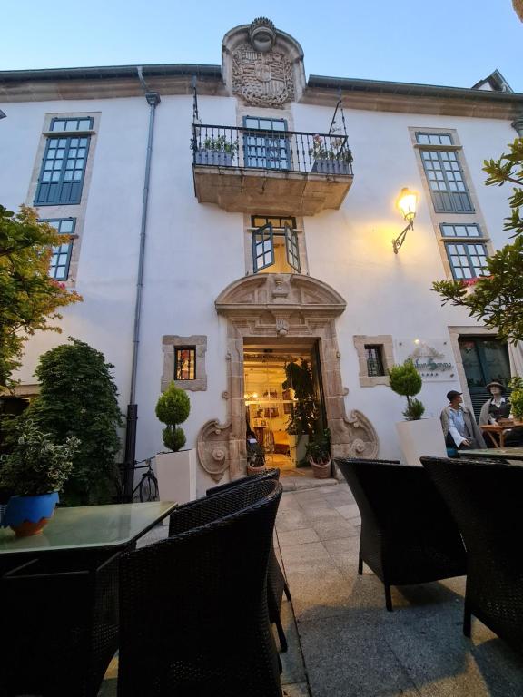 ein Restaurant mit Balkon an der Seite eines Gebäudes in der Unterkunft Hotel Monumento Pazo de Orbán in Lugo