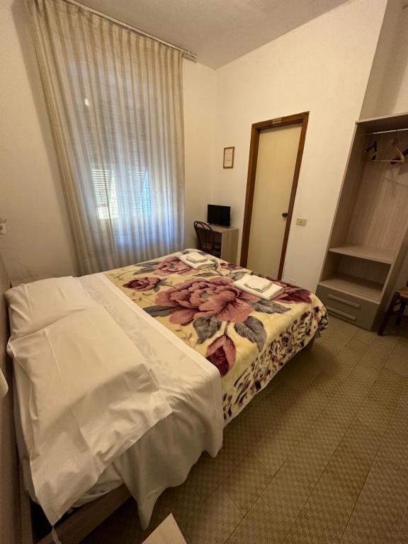 1 dormitorio con 1 cama en una habitación con espejo en Hotel Aurora, en La Spezia