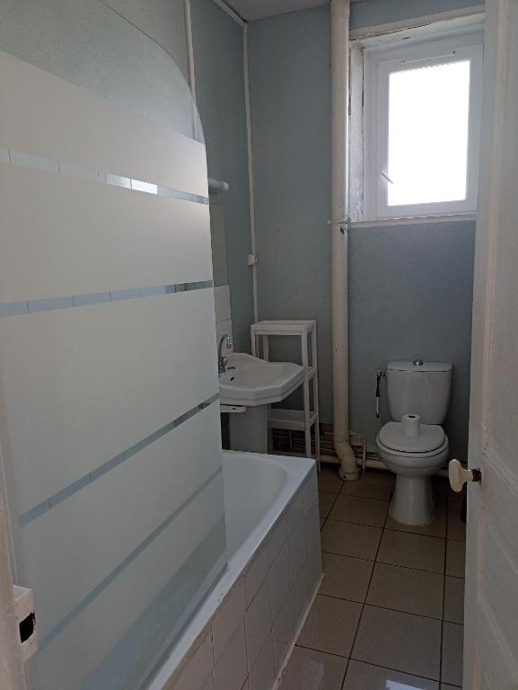 a bathroom with a tub and a toilet and a sink at Centre in Brest