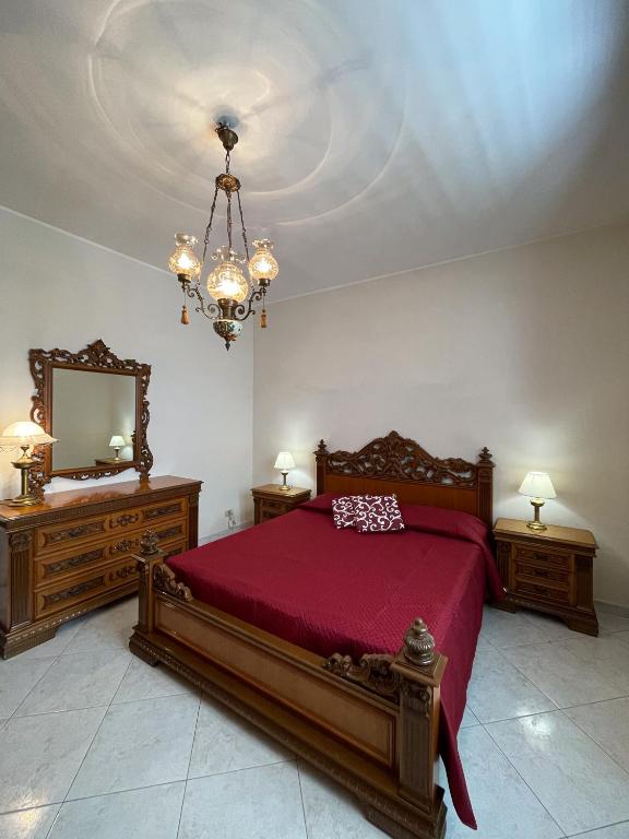 a bedroom with a bed and a mirror and a chandelier at Selinunte Street House in Castelvetrano Selinunte