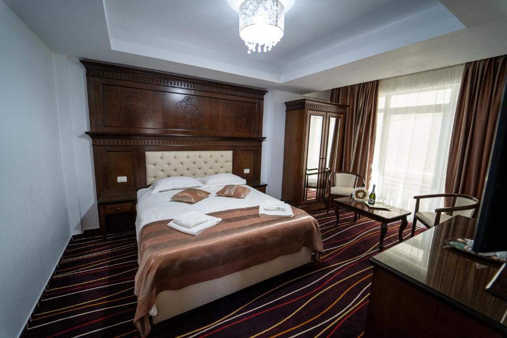 a bedroom with a bed with a wooden headboard at Marina Bay Beach Mamaia Nord in Mamaia Sat/Năvodari