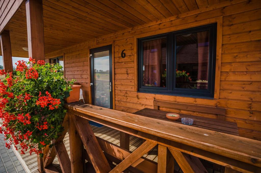 a porch of a cabin with a bench and a window at Havana Sarbinowo in Sarbinowo