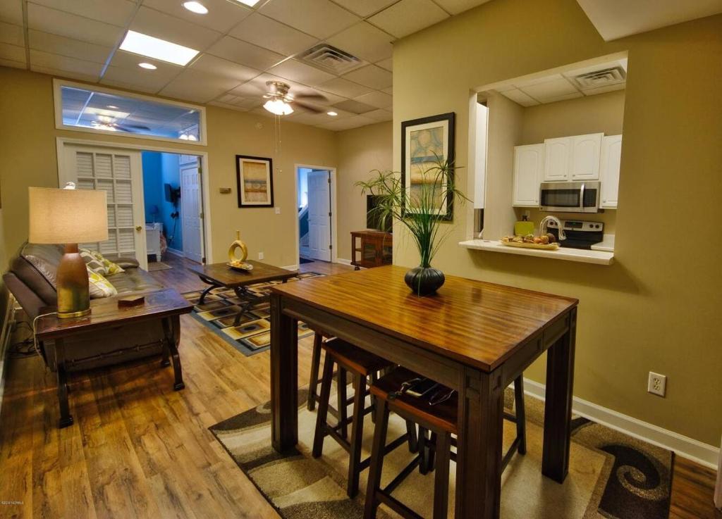 a living room with a wooden table and a kitchen at Turner's loft / sleeps 4 in the heart of the town in Wilmington