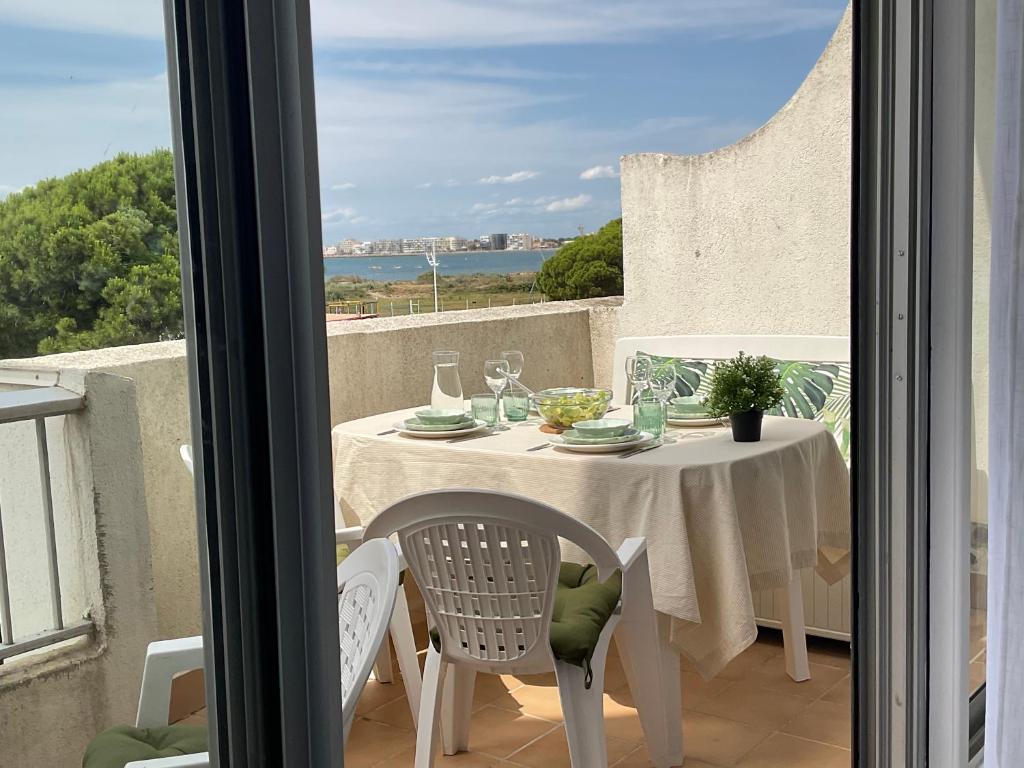 勒格罗-迪鲁瓦Studio le Vue mer Accès direct à la plage Parking privé Clim belle terrasse的阳台上的桌子和椅子，可以欣赏美景