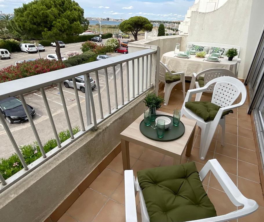 勒格罗-迪鲁瓦Studio le Vue mer Accès direct à la plage Parking privé Clim belle terrasse的阳台配有桌椅。