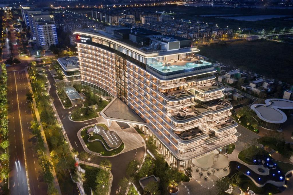 una vista aérea de un edificio alto por la noche en Qinhuangdao Marriott Resort, en Qinhuangdao