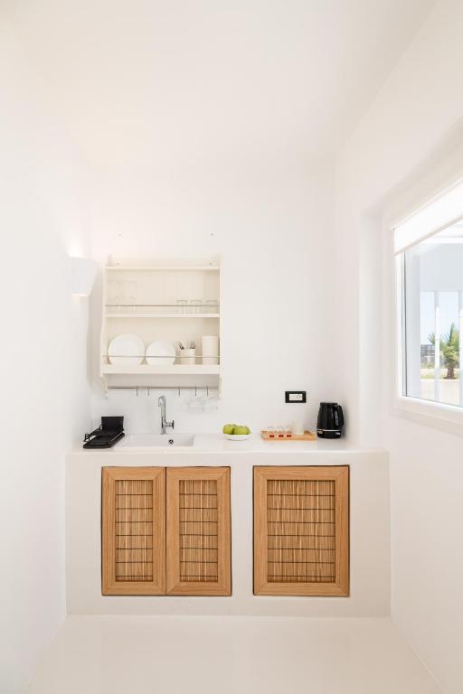 una cucina bianca con lavandino e finestra di Piccole Case a Kamari