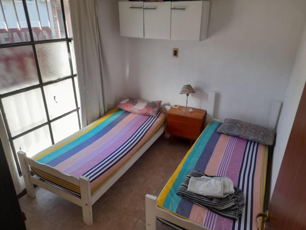 two twin beds in a room with a window at Esquina centrica en Zarate in Zárate