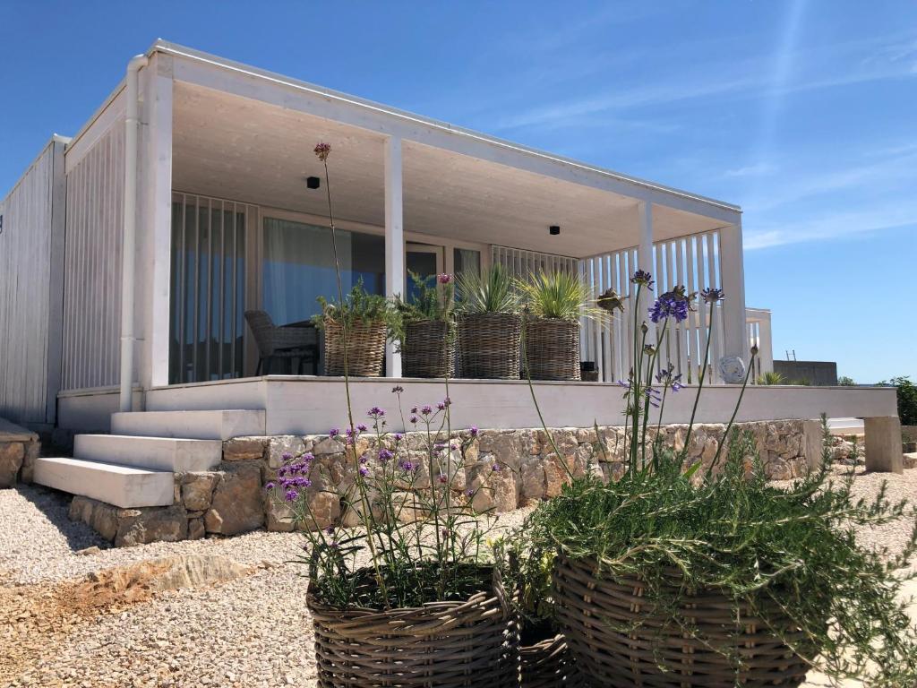 een huis met drie potplanten ervoor bij Buqez Resort Villa SunSet 64 in Drage