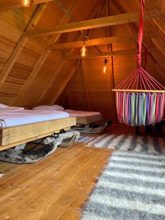 een kamer met een bed en een hangmat op zolder bij La patru daci in Ocna Şugatag