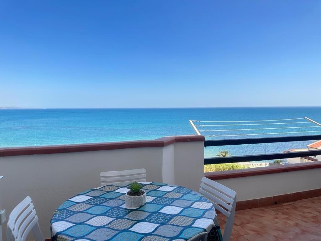 a table and chairs on a balcony with the ocean at Casa panorama Sciacca in Sciacca