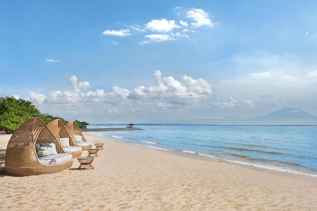 - une rangée de chaises sur une plage donnant sur l'océan dans l'établissement The Westin Resort Nusa Dua, Bali, à Nusa Dua