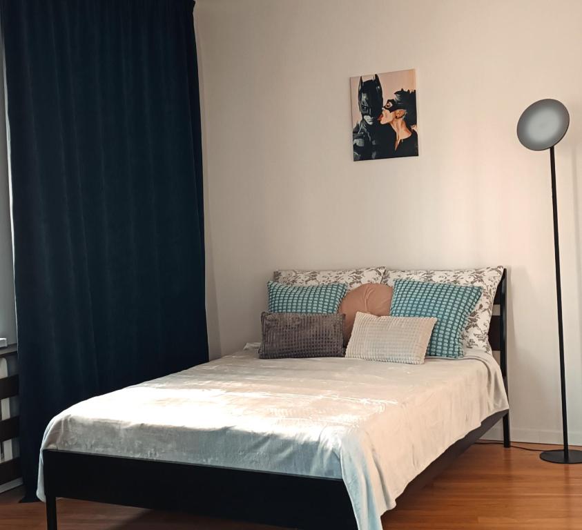 a bed in a room with a blue curtain at Duży prywatny pokój blisko Starego Miasta. Pokój 7 in Warsaw