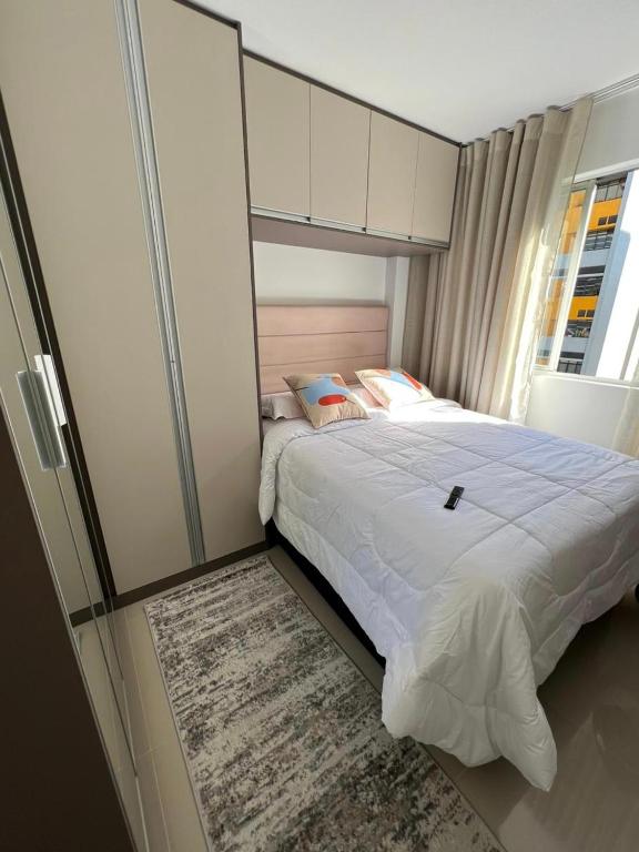 a bedroom with a large bed and a window at Márcia Santos in Curitiba
