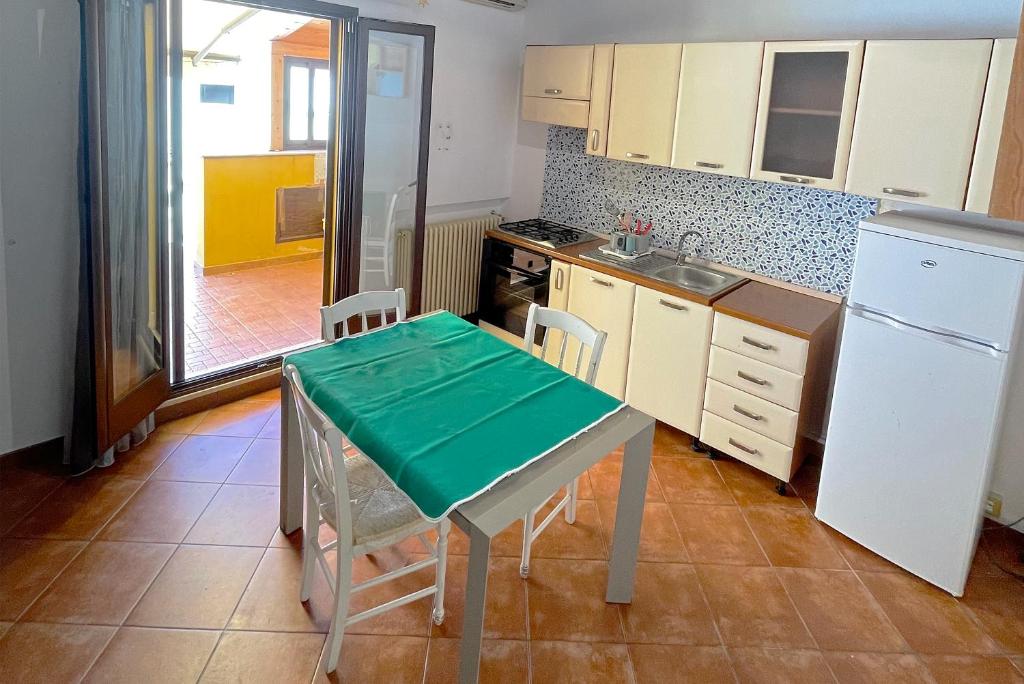 a small kitchen with a table and a refrigerator at Luxury Apartments Campofelice in Campofelice di Roccella