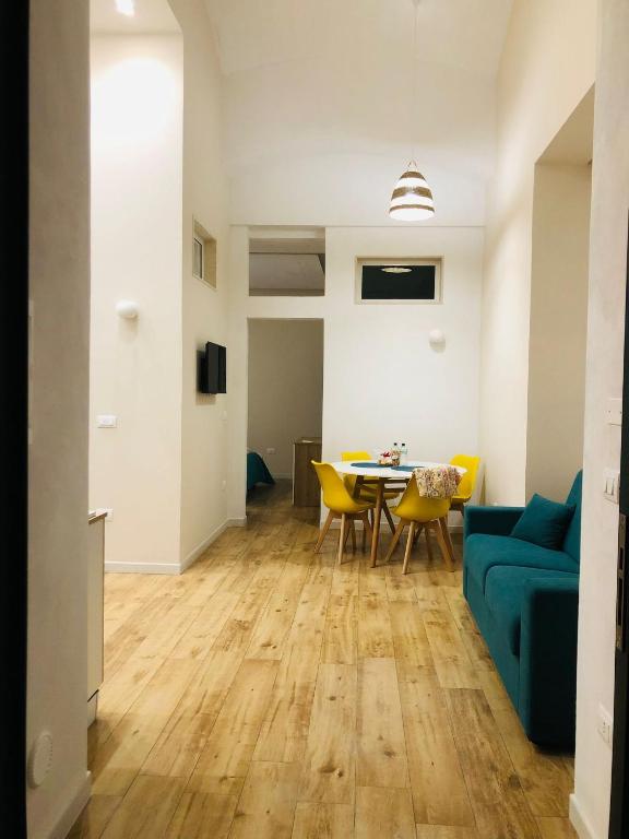 a living room with a blue couch and a table at Suites Elifani Marina in Trani