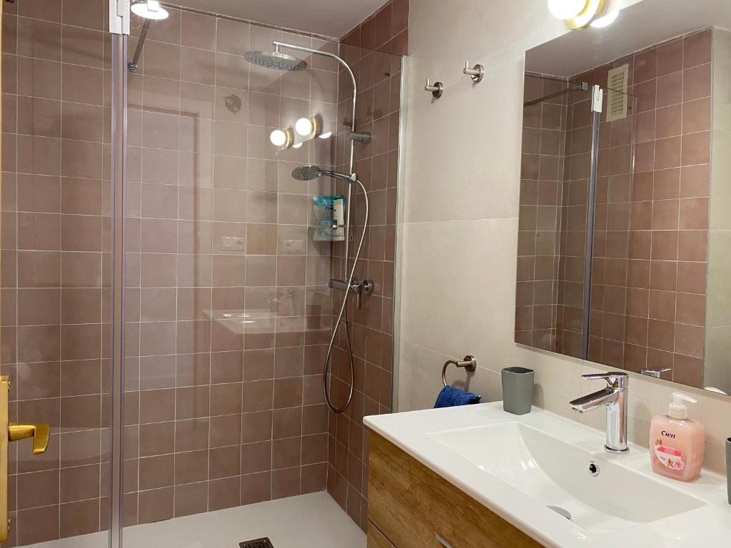a bathroom with a shower with a sink and a mirror at Tranquilidad y confort, Apartamento reformado en Cambrils in Cambrils