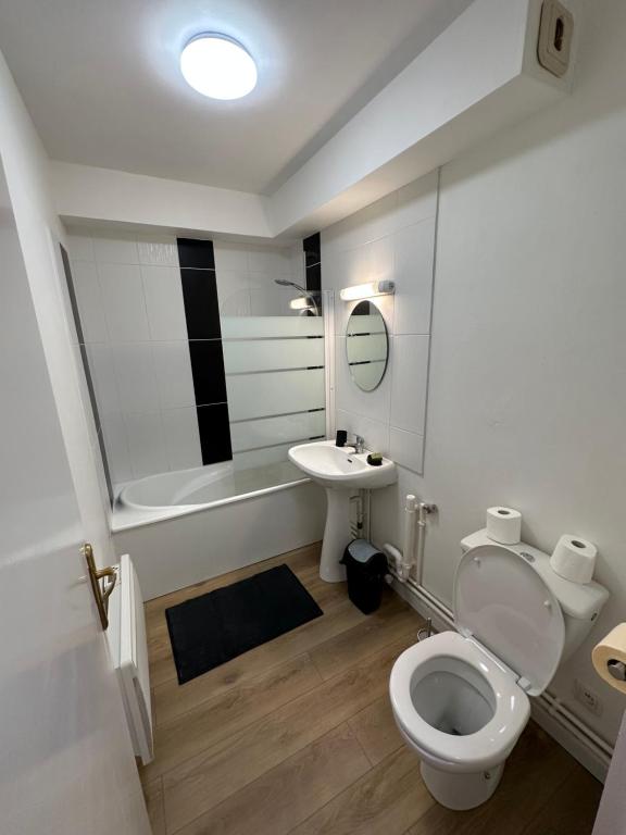 a bathroom with a white toilet and a sink at Le Jacquard in Calais