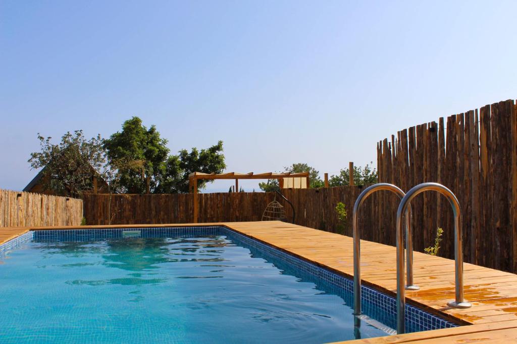 a swimming pool in a backyard with a wooden fence at Likya Garden Life in Gâvurağılı