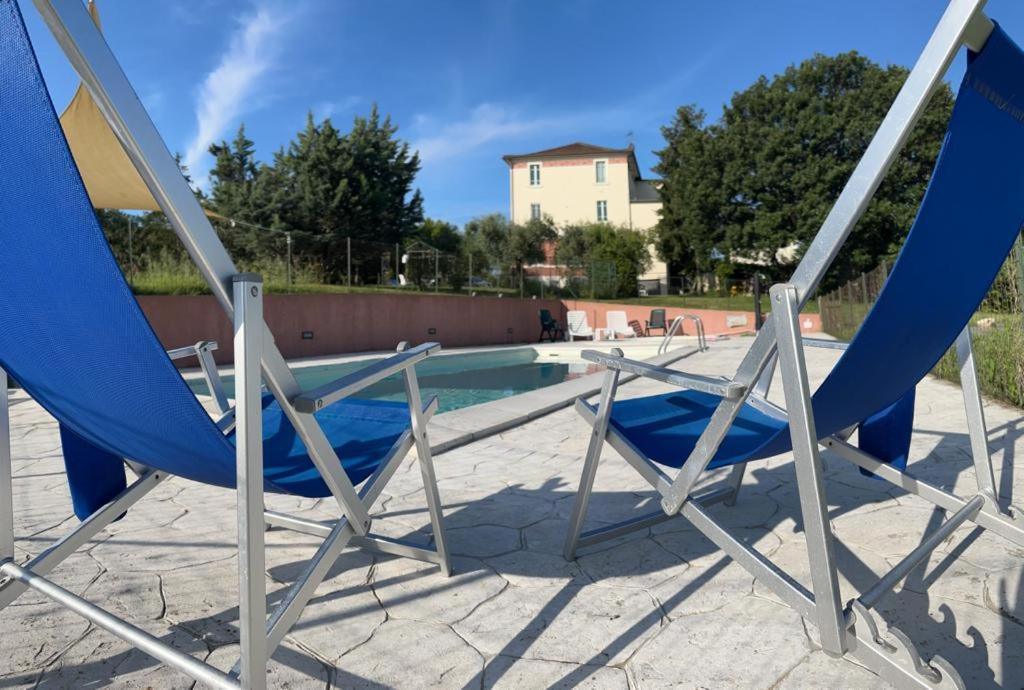 zwei blaue Stühle neben einem Pool in der Unterkunft La Dispensa in Montalto delle Marche