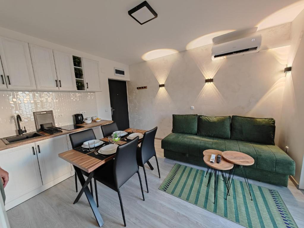 a living room with a green couch and a table at Apartman Holiday 1 in Veliko Gradište