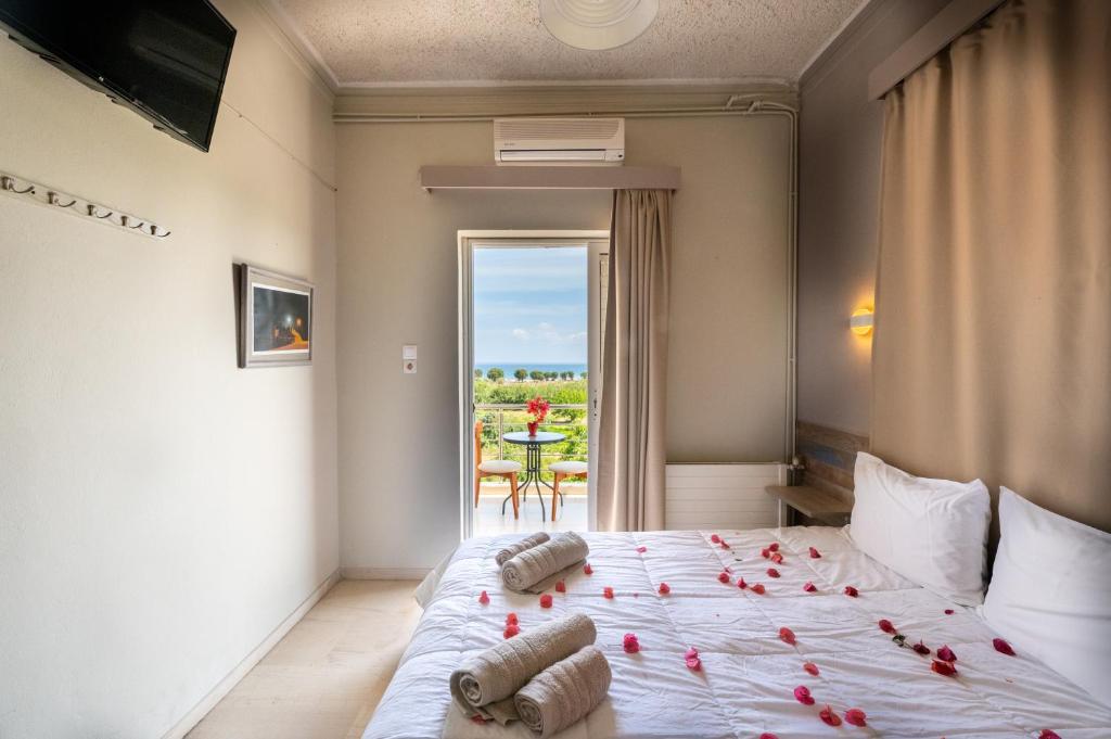 a bedroom with a bed with red roses on it at Bikakis Family Apartments in Kissamos
