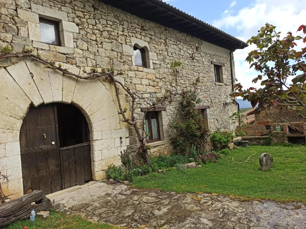 an old stone building with a door and a yard at Casa Rural TTIPIAENEA Landetxea in Ariz