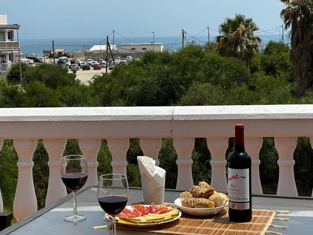 een tafel met twee glazen wijn en eten op een balkon bij La Cizaña Dúplex By Holiday Homes Málaga in Torremolinos