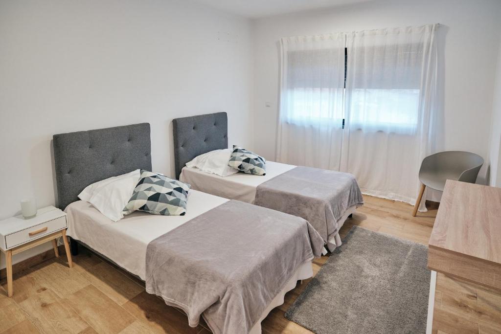 1 dormitorio con 2 camas y ventana en feel... Azores - apartments, en Velas