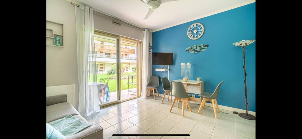 un salon avec une table et un mur bleu dans l'établissement appartement front de mer, à Deauville