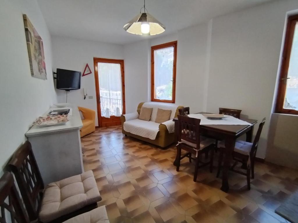 ein Wohnzimmer mit einem Tisch und einem Sofa in der Unterkunft Casa Crara in Cala Gonone