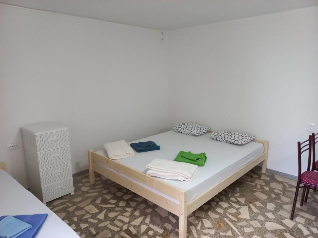 um quarto com uma cama branca e 2 cadeiras em Markos Apartments Sutomore em Sutomore