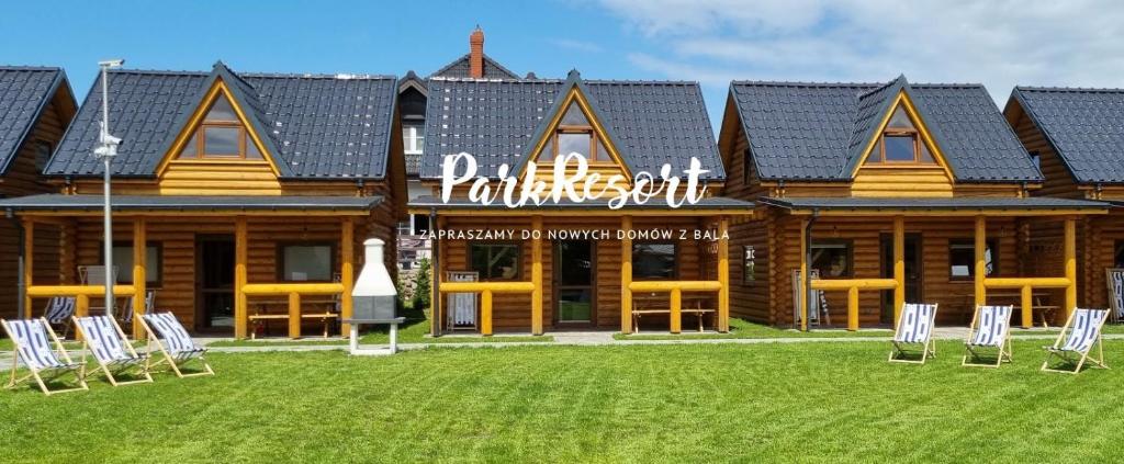 ein Blockhaus mit Stühlen davor in der Unterkunft Park Resort Trzęsacz in Trzęsacz