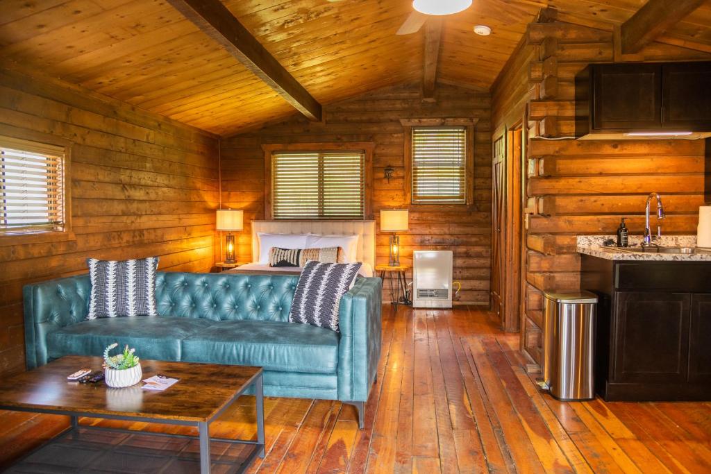a living room with a blue couch and a table at High Creek Lodge and Cabins in Pagosa Springs