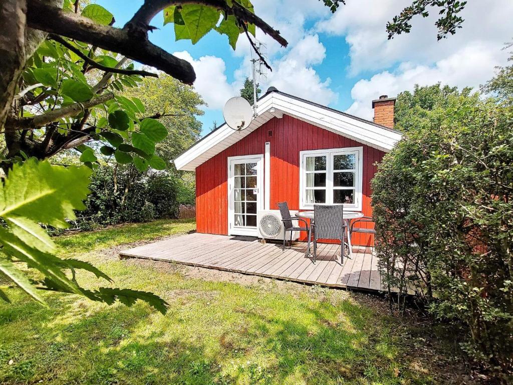 a red tiny house on a wooden deck at 4 person holiday home in Hemmet in Hemmet