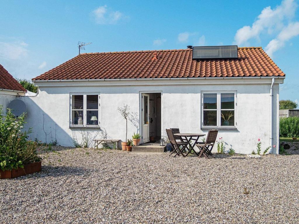 una casa blanca con una mesa y sillas frente a ella en Holiday home Lemvig XLIII en Lemvig