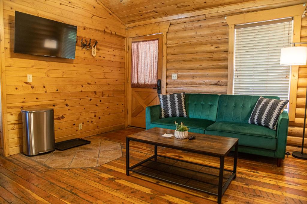 a living room with a green couch and a table at High Creek Lodge and Cabins in Pagosa Springs