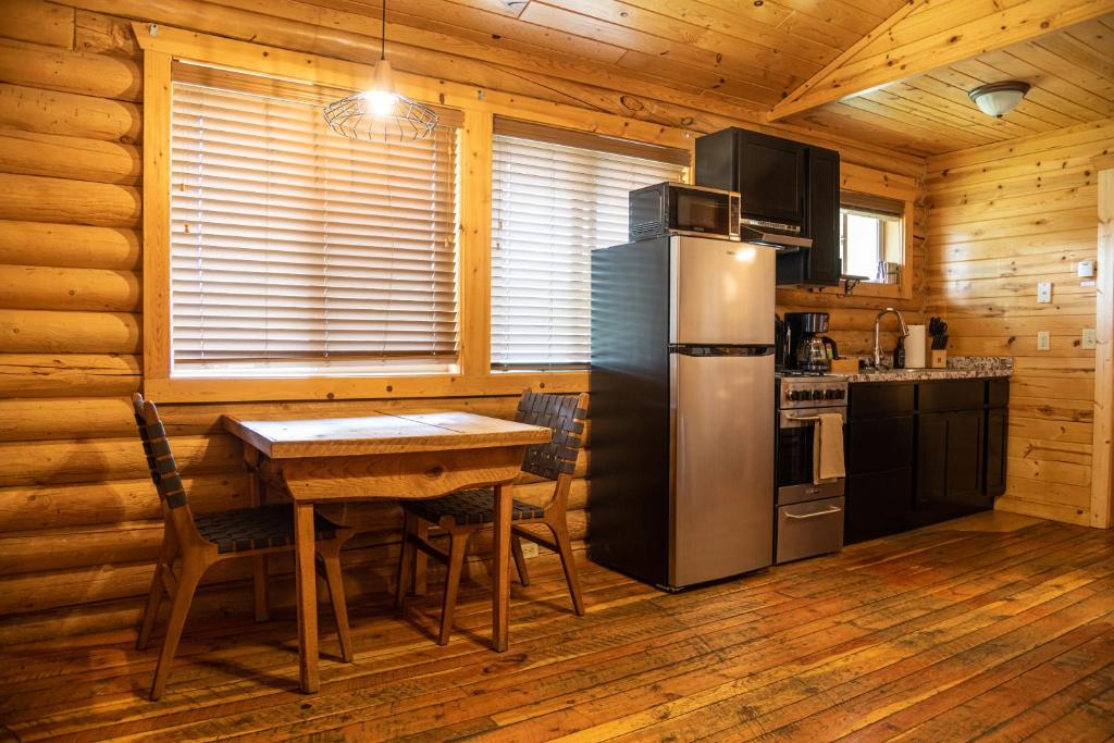 a kitchen with a table and a refrigerator in a cabin at High Creek Lodge and Cabins in Pagosa Springs
