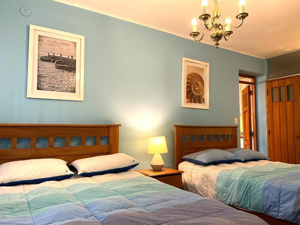 een slaapkamer met 2 bedden en een kroonluchter bij R° | 1BR apartment infront Chorrillos Sea in Lima