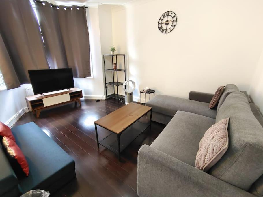 uma sala de estar com um sofá e uma mesa em Stylish flat in London with free parking em Londres
